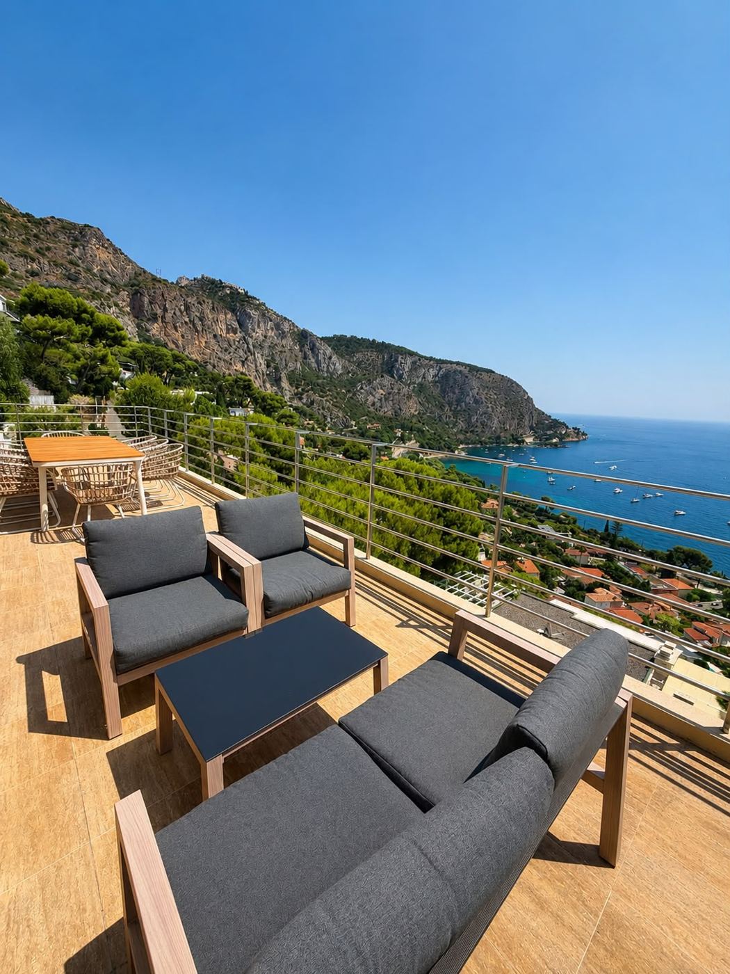 Terrasse mit Lounge-Möbeln und Blick auf die Küste
